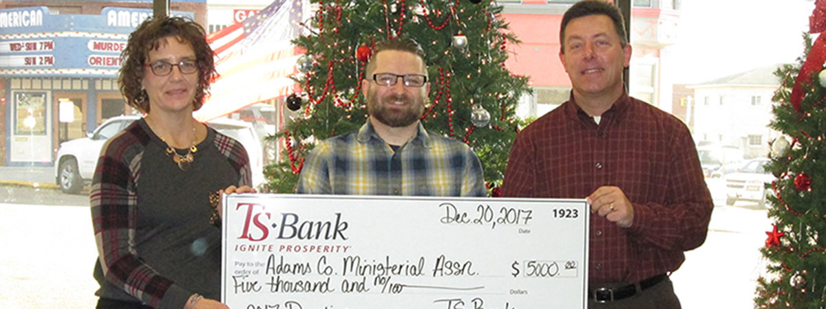 ts bank employees deliver check to adams county ministe