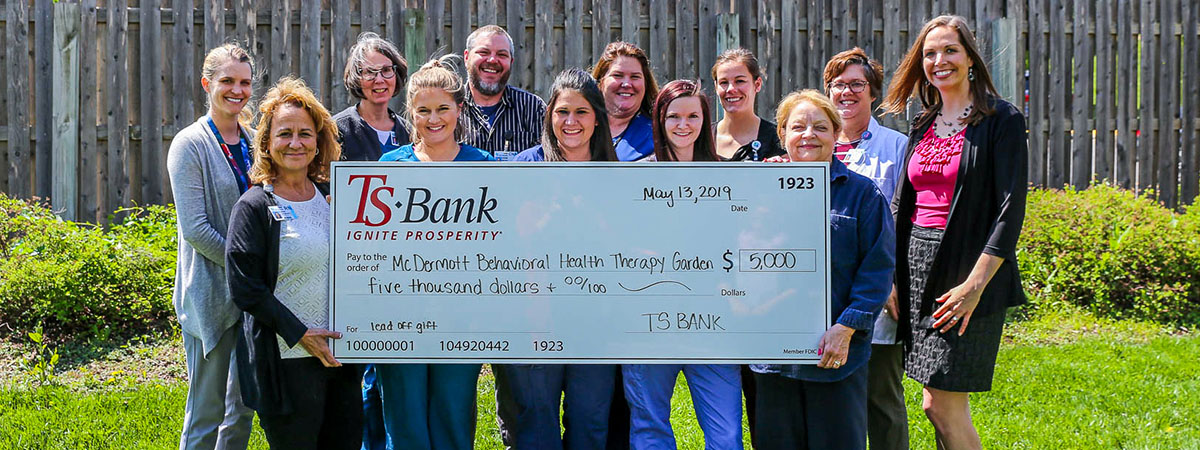 ts bank employees pose for a $5000 check photo with mem