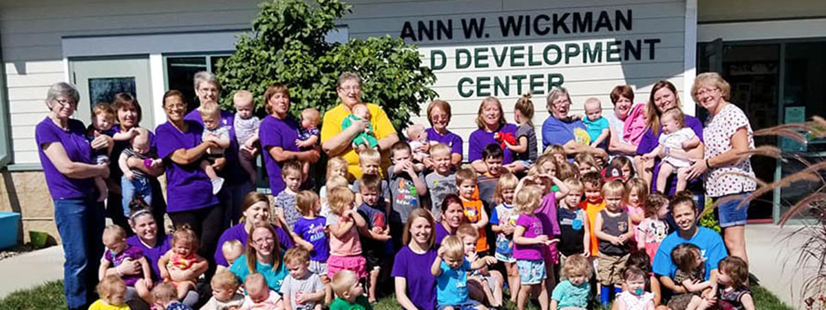 children and staff standing outside of the ann wickman 