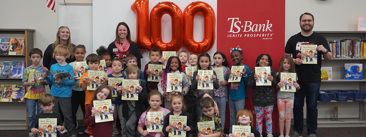 Students, TS Bank Employees and staff pose with their b