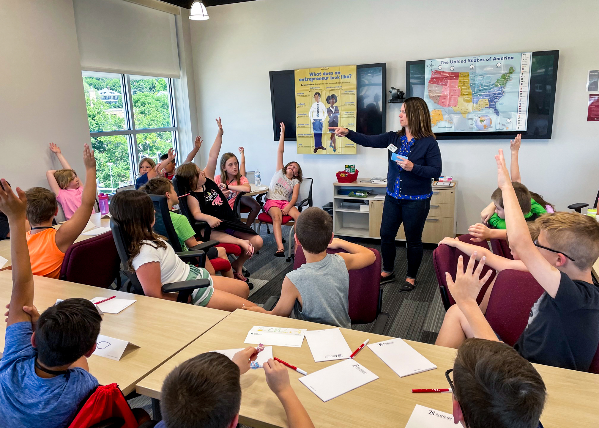 students raising hands for teacher