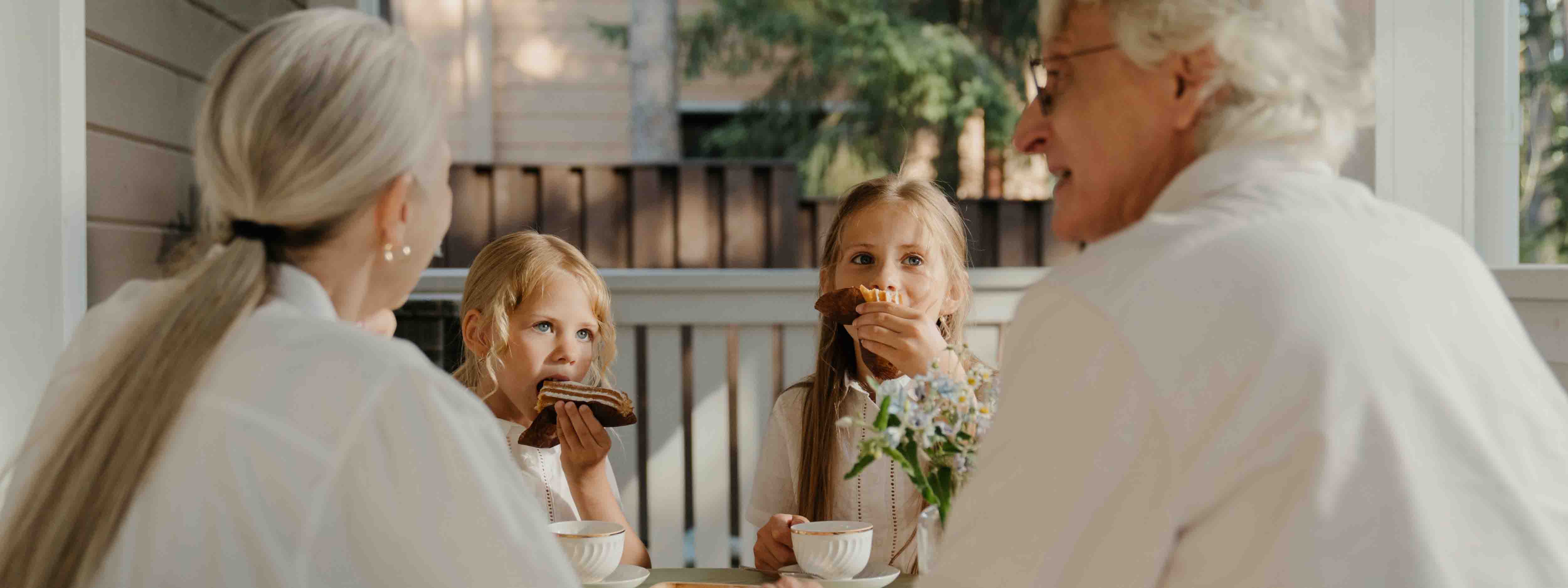 Two grandkids eating breakfast with their grandparents