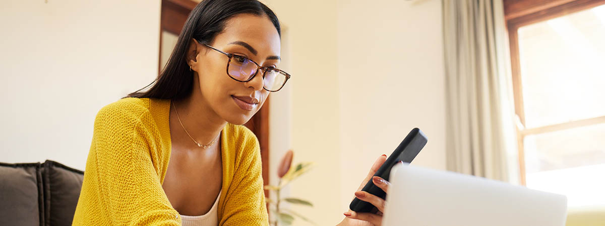 Woman looking on phone and laptop