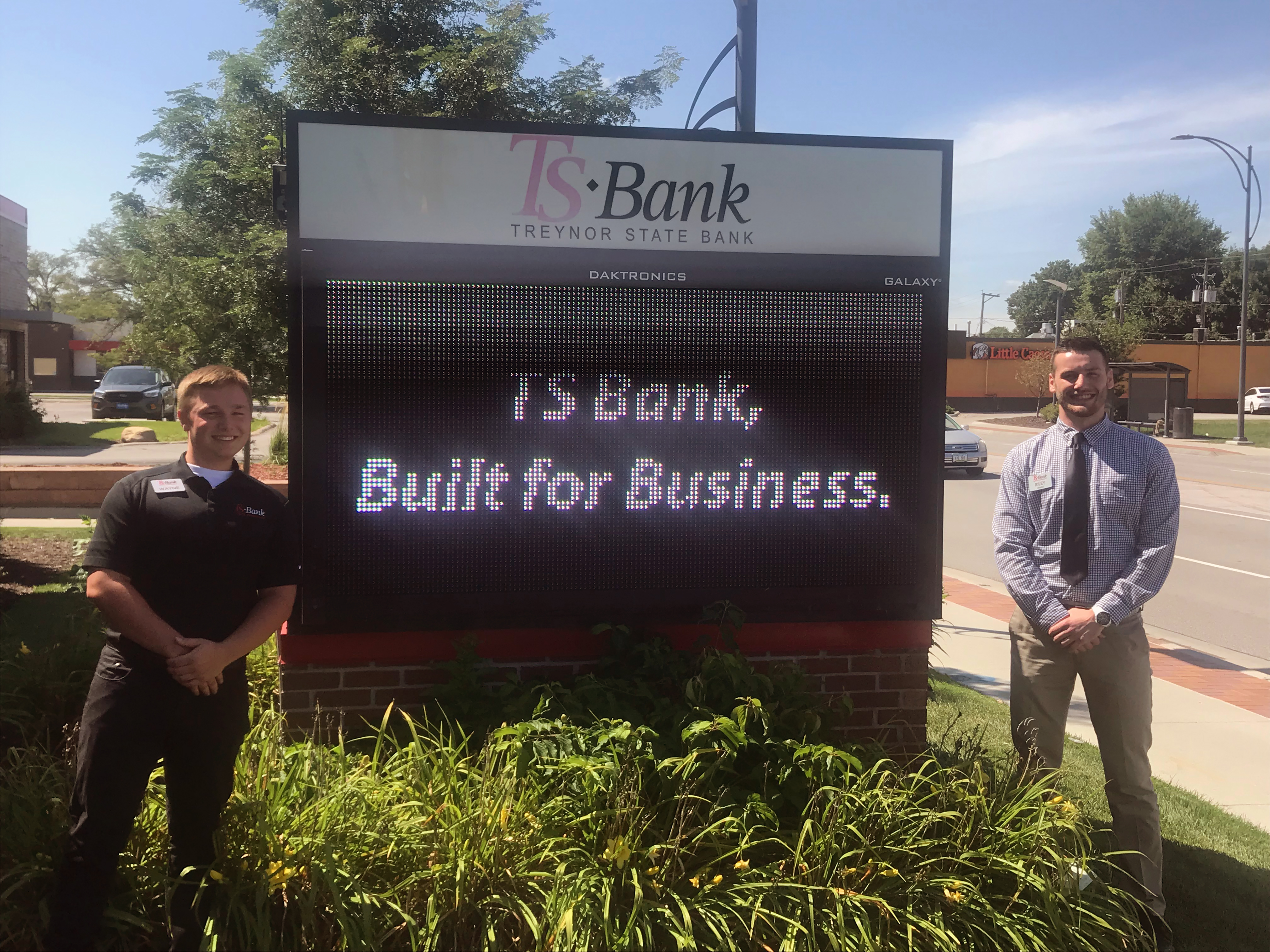 ts bank employees posing by digital sign