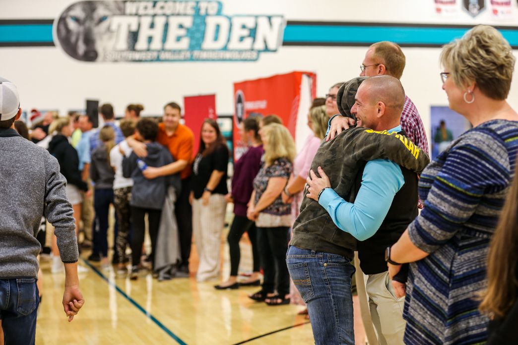 students hugging staff at assembly