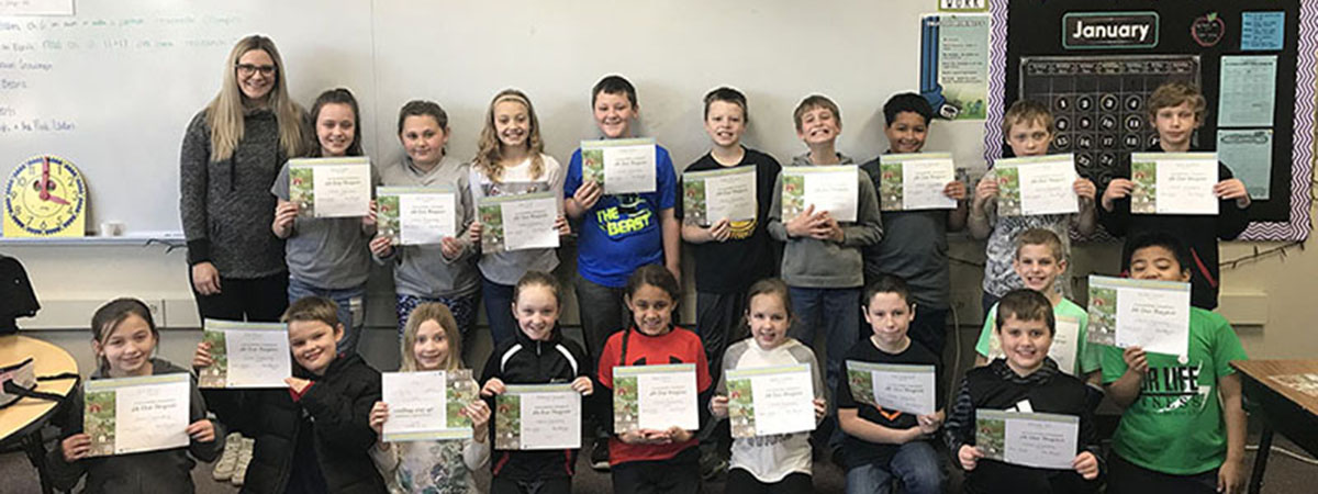 ts bank employee poses with children holding their cert