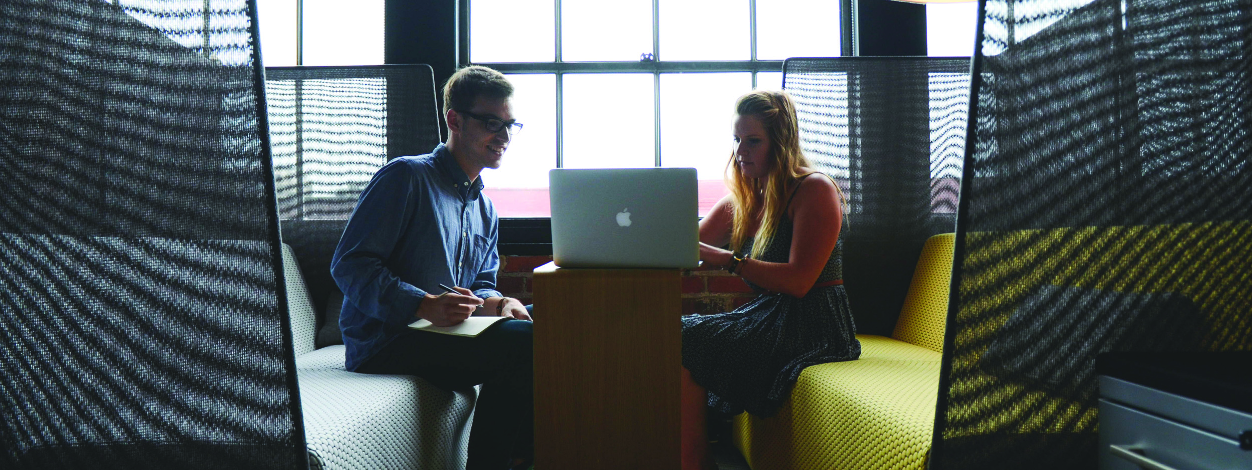 two people working together on a laptop