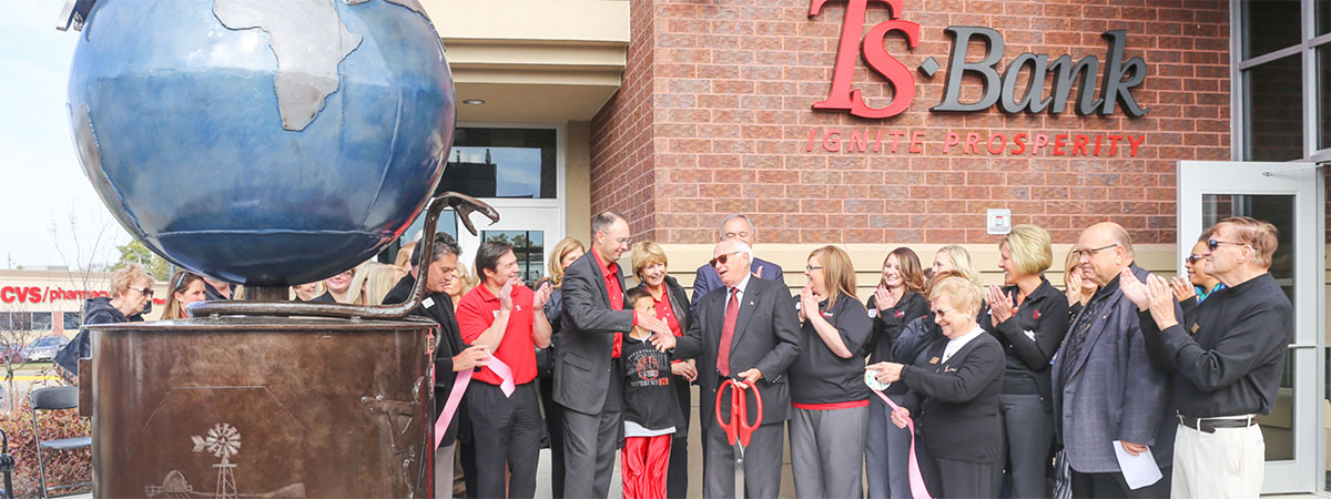 ts bank's josh guttau speaks to a crowd in front of the