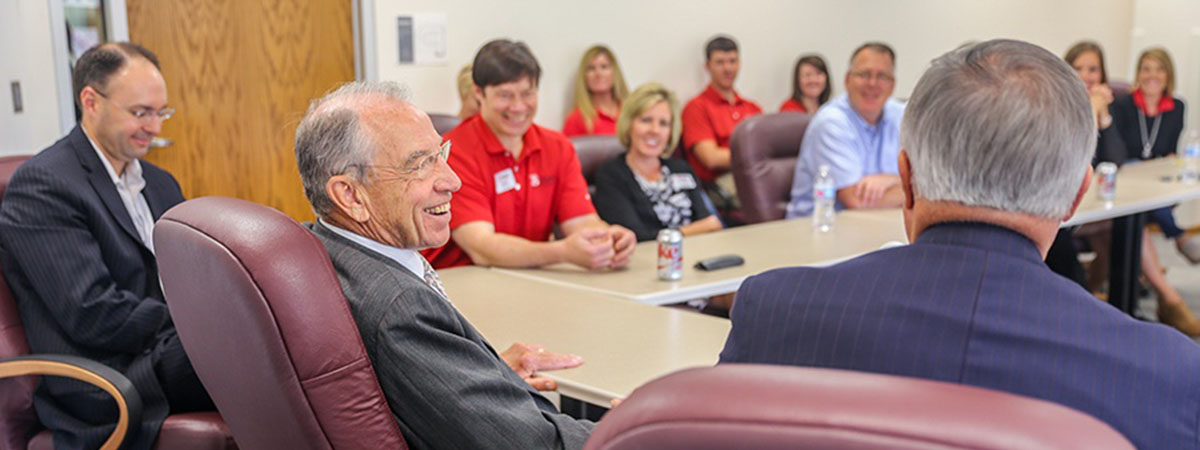 senator grassley laughs with ts bank employees in a con
