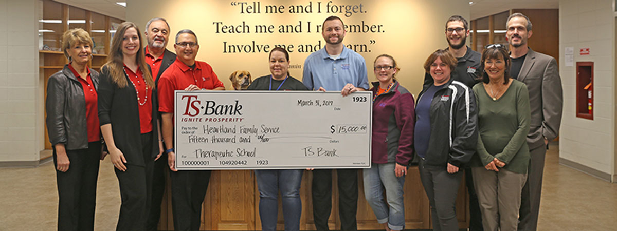 ts bank employees delivering check to heartland service