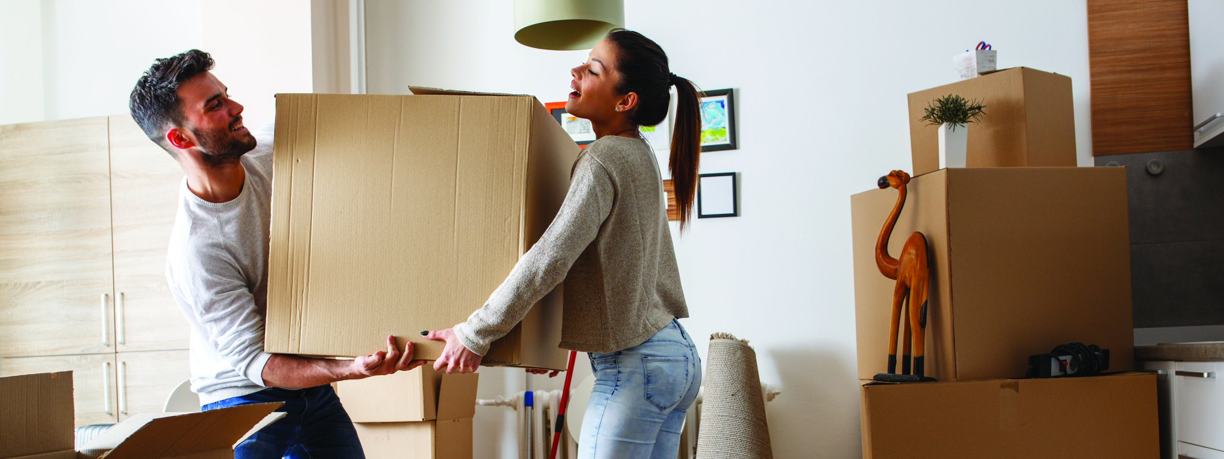 a young couple moving boxes into a new place