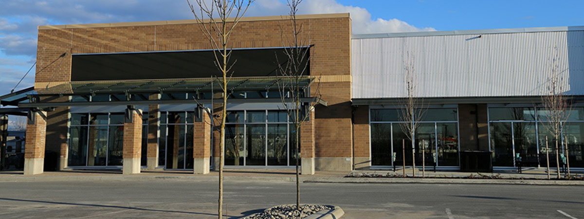 an empty brick commercial building and a parking lot