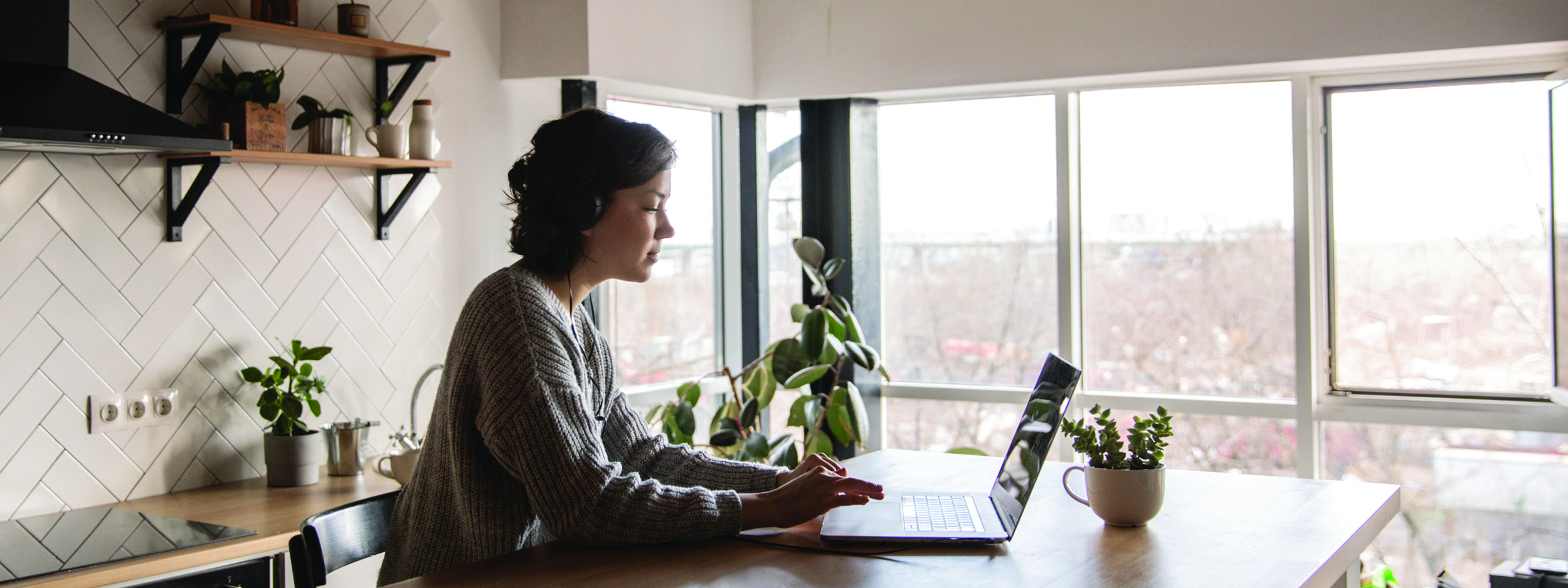 a woman working on her laptop at a table