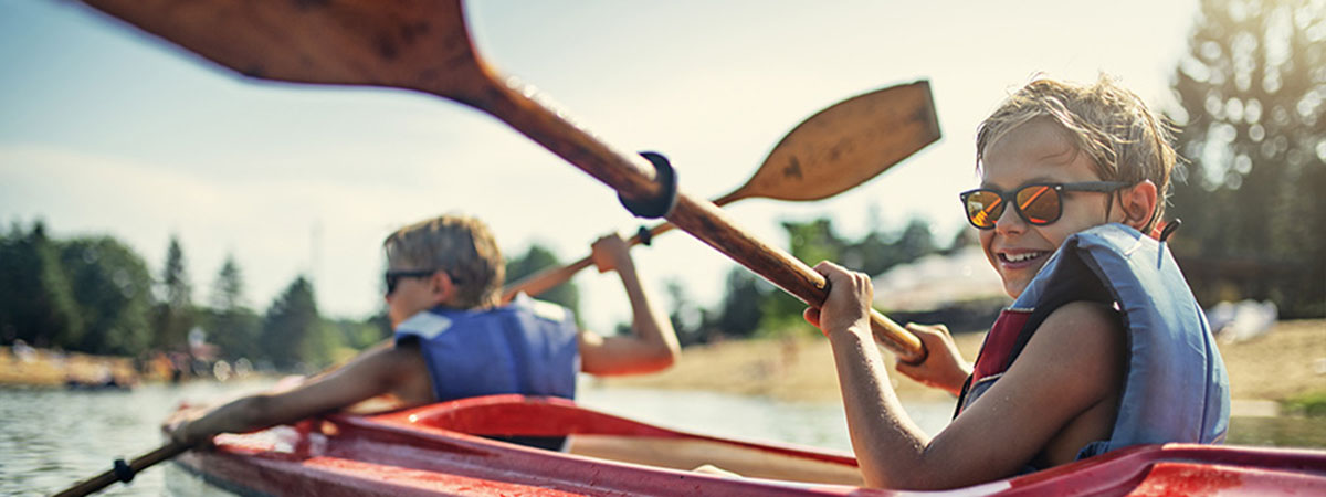 child in kayak smiling on a lake