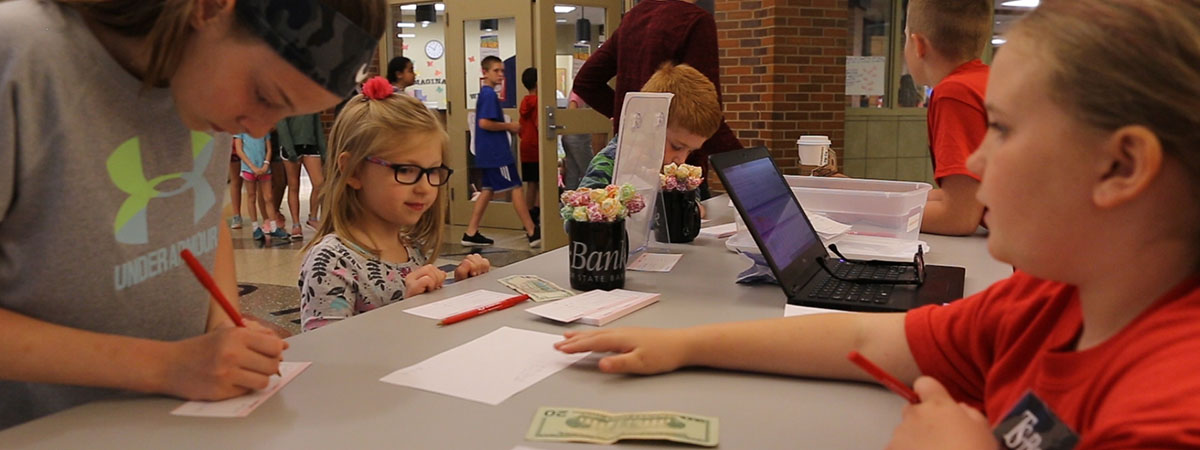 young girl conducting banking activity at an in-school 