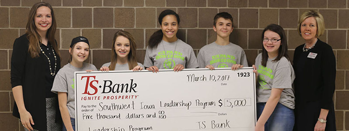 ts bank employee handing over check to southwest iowa l