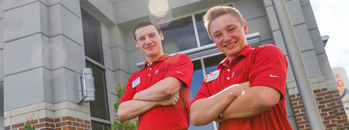 ts bank employees wayne and riley stand in front of a b