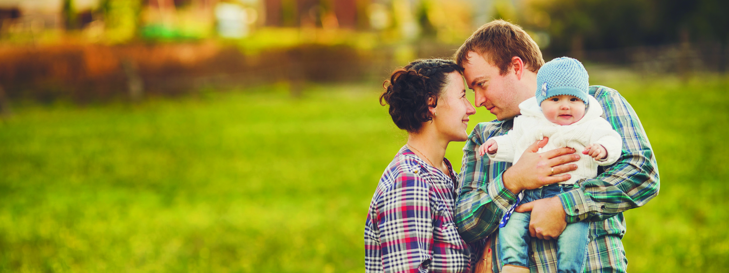 a young family standing in a field together