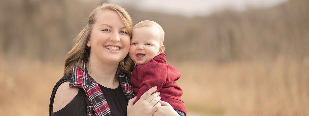 employee krysta stevens poses outside with her young so