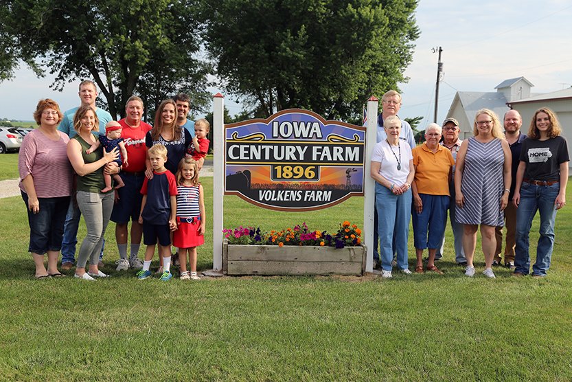 extended volkens family posing by century farm sign