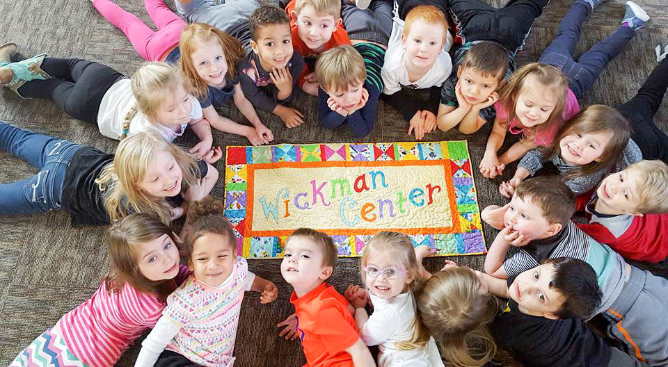 children smiling for camera at ann wickman center